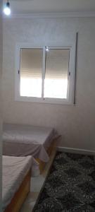 a bedroom with two beds and a window at Al Hoceima Bades in Al Hoceïma