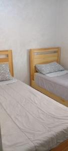 two beds sitting next to each other in a room at Al Hoceima Bades in Al Hoceïma