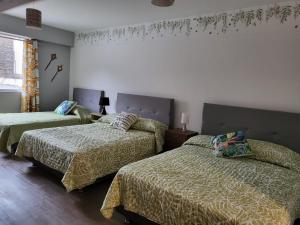 um quarto com 2 camas com lençóis verdes e uma janela em Alojamiento San Francisco Preciosas habitaciones con baño privado em Lima