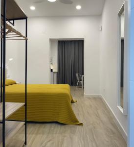 a bedroom with a yellow bed and white walls at Brand NEW Studio Centro, Atocha - Museums in Madrid