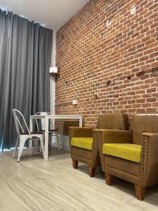 a living room with chairs and a brick wall at Brand NEW Studio Centro, Atocha - Museums in Madrid