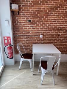 a white table and two chairs in front of a brick wall at Brand NEW Studio Centro, Atocha - Museums in Madrid