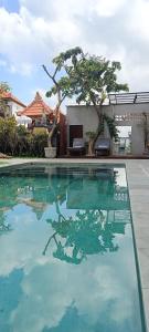 a swimming pool with a reflection in the water at The Breeze Stay and Surf Canggu Bali in Canggu
