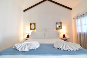 a bedroom with a large white bed with two lamps at La Casa de Reyes in Peñaflor