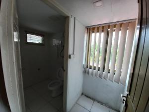 bagno con servizi igienici e finestra. di Semi detached At Tabuan Jaya,13BR By Natol Homestay-London a Kuching