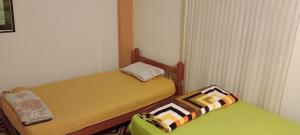 Dos camas en una habitación pequeña con 3 estrellas que dice que es lo que dice en Travelershouse Casa Hospedaje, en Huanchaco
