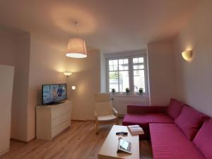 a living room with a purple couch and a table at Sopot Baltic in Sopot