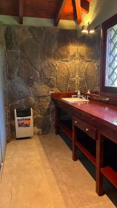 a bathroom with a sink and a stone wall at Villa Berna Casa Boutique in Villa Berna