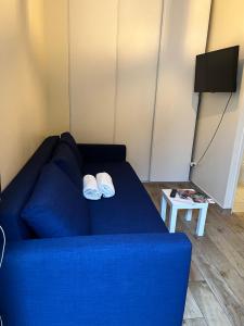 a blue couch with two white slippers on it at Joli studio proche gare in Brétigny-sur-Orge