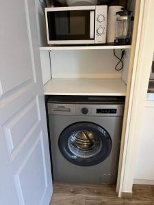 a microwave and a washing machine in a kitchen at Joli studio proche gare in Brétigny-sur-Orge