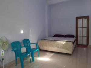 um quarto com duas cadeiras azuis e uma cama em Riana's Homestay em Rantepao