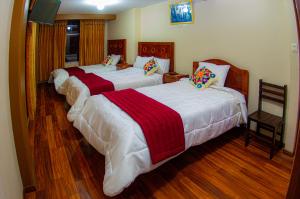 3 camas en una habitación con suelo de madera en Hostal Mirador Korichaska en Puno