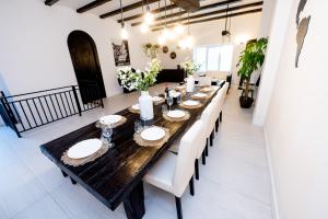 una sala da pranzo con un lungo tavolo e sedie bianche di Casa Bolta Rece a Sighetu Marmaţiei