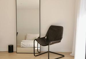 a black chair in a room with a mirror at Collingwood Studio Hideaway in Melbourne