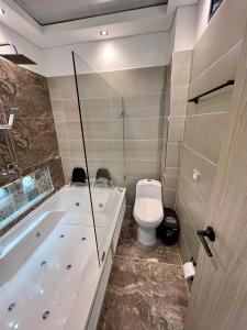 a bathroom with a toilet and a bath tub at HOTEL TORRE DELUXE ¨SANTORINI¨ in Doradal