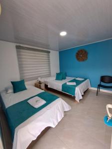 um quarto com duas camas e uma parede azul em Mary & Matt lodge em Providencia