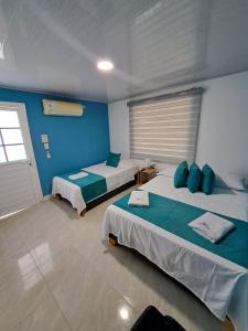 two beds in a room with blue walls at Mary & Matt lodge in Providencia