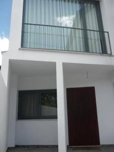 a white house with a balcony on top of it at Casa da Terra in Góis