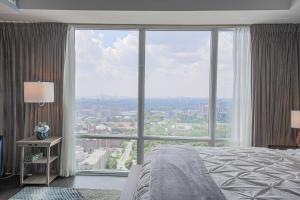 een slaapkamer met een groot raam met uitzicht op de stad bij Luxury view in Toronto Downtown 3 Bedroom 2.5 Bathroom 1 Parking in Toronto