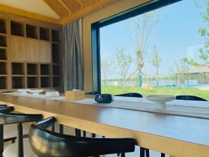 ventana grande en una habitación con mesa y sillas en Yuncheng Yunxi Furusato-Banma Resort, en Yuncheng