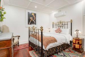 una camera con un letto bianco e nero e un comò di 'Lady Beatle' Quirky Character Terrace near Harbour a Sydney
