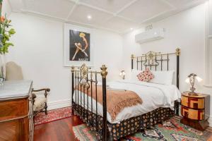 a bedroom with a black and white bed and a dresser at 'Lady Beatle' Quirky Character Terrace near Harbour in Sydney