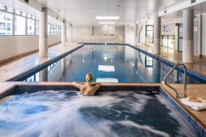 un homme nageant dans une piscine dans l'établissement Top of the Town with Sydney CBD at its Doorstep, à Sydney