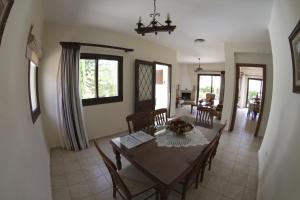 a dining room and living room with a table and chairs at Eve Pissouri Soultanina Villa in Pissouri