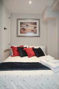 a bedroom with a large bed with red and black pillows at Toronto Junction Hideaway in Toronto