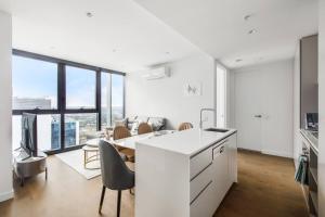 cocina y sala de estar con mesa y sillas en The View on Elizabeth - Chic City Centre Living en Melbourne