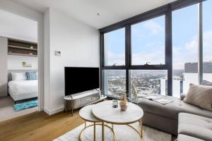 un soggiorno con divano e una grande finestra di The View on Elizabeth - Chic City Centre Living a Melbourne