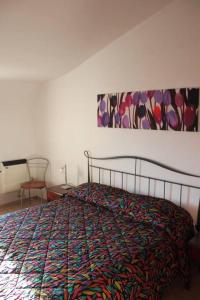 een slaapkamer met een bed met een kleurrijke deken erop bij Appartamento con Vista Lago in Lorica