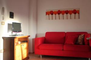 a living room with a red couch and a tv at Appartamento con Vista Lago in Lorica