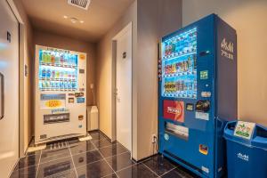 una máquina expendedora azul en una habitación en 谷町君Hotel 難波77, en Osaka
