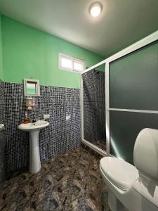 y baño con aseo, lavabo y ducha. en Hotel Pazifico en Monterrico, en Monterrico