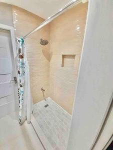 y baño con ducha de azulejos. en The Shelton Tower 1 en Montego Bay
