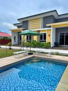a house with a swimming pool in front of a house at Kedawang Village Langkawi in Pantai Cenang