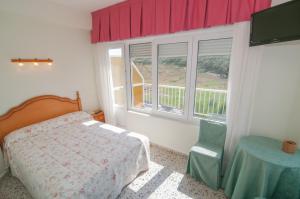 a bedroom with a bed and a table and windows at Hotel Costa de Ajo in Ajo +88 photos