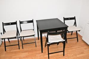 a black table and four chairs in a room at Casa Mario in Sibiu