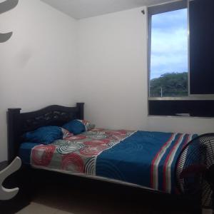 a bed in a bedroom with a window at Apartamento entero Valledupar in Valledupar