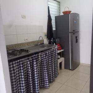 a kitchen with a stove and a refrigerator at Apartamento entero Valledupar in Valledupar