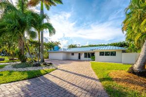 a house with palm trees and a brick driveway at Life is Blue in Fort Lauderdale
