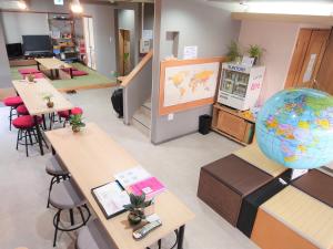 a classroom with tables and a large globe on the wall at Stay Inn KOTO in Kyoto