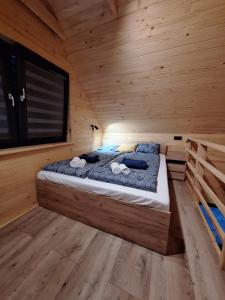 1 dormitorio con 1 cama en una cabaña de madera en Pod gwiazdami, en Kunów