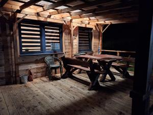 una terraza de madera con una mesa de madera y un banco en Pod gwiazdami, en Kunów