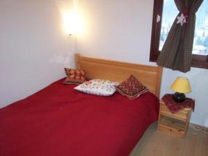 a red bed with pillows on it in a room at Appartement Morzine, 2 pièces, 4 personnes - FR-1-754-67 in Morzine