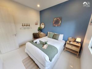 ein Schlafzimmer mit einem großen weißen Bett und einer blauen Wand in der Unterkunft Cute Boys House คิวท์บอยส์เฮาส์ in Ban Bo Prakhon + 57 Fotos