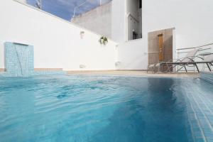 una piscina al lado de un edificio en Sitges Centre Mediterranean House- 5 Bedroom, 4 Bathroom, Terrace Courtyard, Private Rooptop Pool, en Sitges