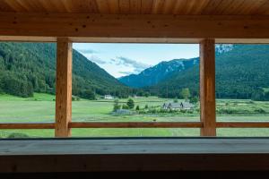 ein Fenster in einer Hütte mit Bergblick in der Unterkunft Maso Torbiera- Rural and Mountain lodging in Fiavè