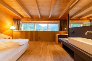 1 dormitorio grande con 1 cama y lavamanos en Maso Torbiera- Rural and Mountain lodging, en Fiavè